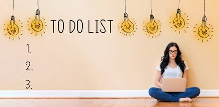 To do list with young woman using a laptop computerの写真素材
