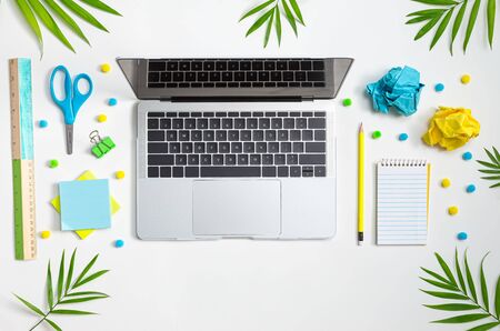 Laptop computer with office stationary supplies from aboveの写真素材