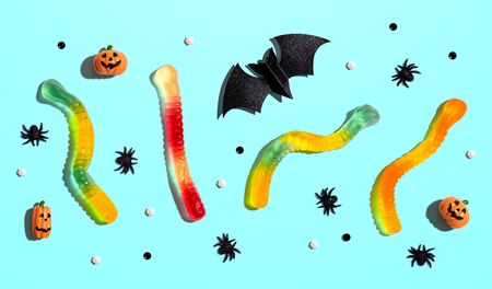 Halloween objects with gummy worms - overhead view flat lay