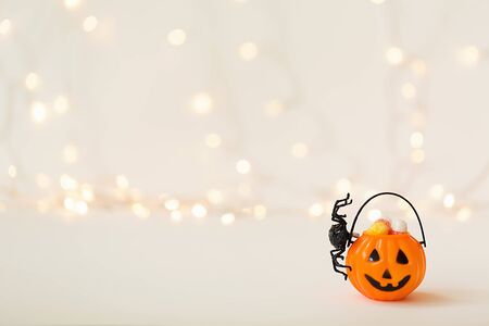 Halloween pumpkin with spider on a shiny light backgroundの写真素材