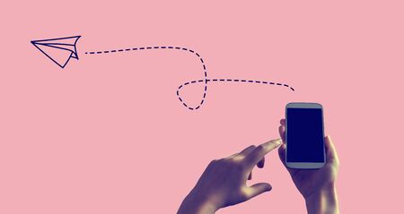 Paper airplane with person holding a white smartphoneの写真素材