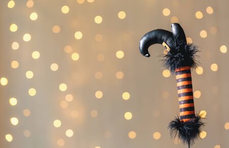 Halloween theme with witches leg decoration on a shiny light background