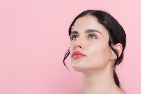 Beautiful young woman with skin care theme on a pink backgroundの写真素材