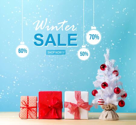 Winter sale message with a white Christmas tree and gift boxesの写真素材