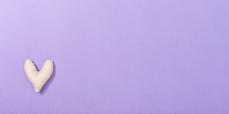 Valentines day heart shaped pillow on a purple paper backgroundの写真素材