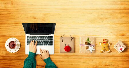 Christmas giftboxes with person using a laptop computer - overhead view