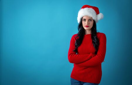 Young woman with a Santa hat on a dark blue backgroundの写真素材