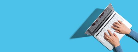 Person using a laptop computer from aboveの写真素材