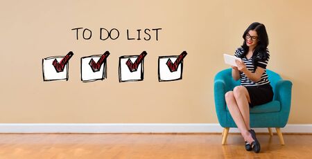 To do list with young woman using a tablet computerの写真素材