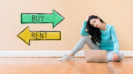 Buy or rent concept with young woman using a laptop computerの写真素材