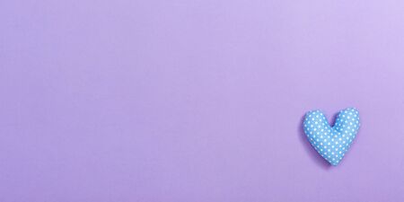 Valentines day heart shaped pillow on a purple paper backgroundの写真素材