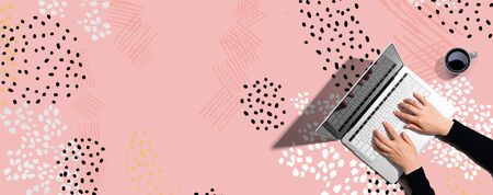 Person using a laptop computer on memphis backgroundの写真素材