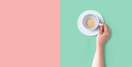 Female hand holding a tea cup overhead view - flat layの写真素材