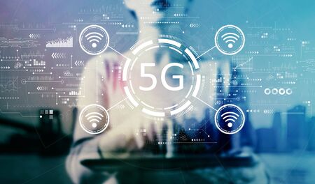 5G network with businesswoman using a tablet on a city backgroundの写真素材