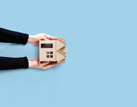 Woman holding a cardboard house overhead viewの写真素材