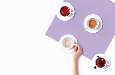Female hand holding a tea cup overhead view - flat layの写真素材
