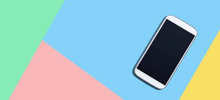 White smartphone with black screen from above - flat lay
