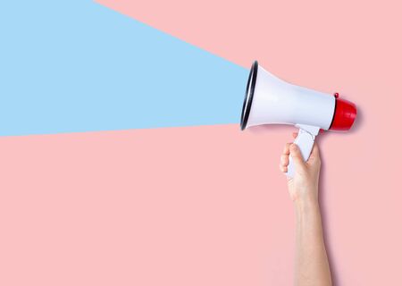 Person holding a megaphone with hard shadowの写真素材