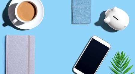 Smartphone with a piggy bank and notebooks - flat layの写真素材