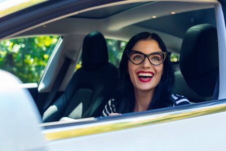 Woman in a self-driving autonomous electric vehicle with hands off the steering wheelの写真素材