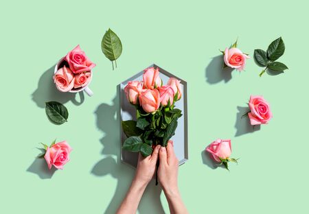 Woman holding pink roses overhead view - flat layの写真素材