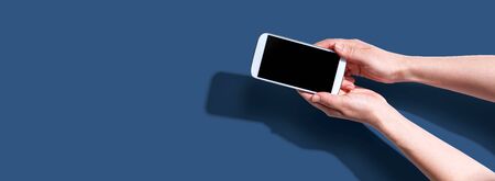 Person using a white smartphone from aboveの写真素材