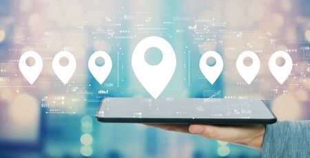 Map pin concept with man holding a tablet computer