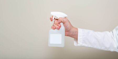 Medical doctor using a spray cleaner bottleの写真素材