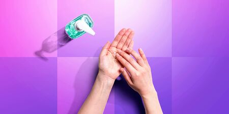 Applying sanitizer gel - healthcare and hygiene concept