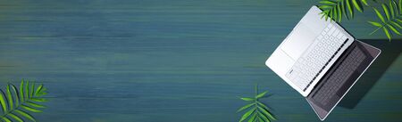 Laptop computer with tropical plants - flat layの写真素材