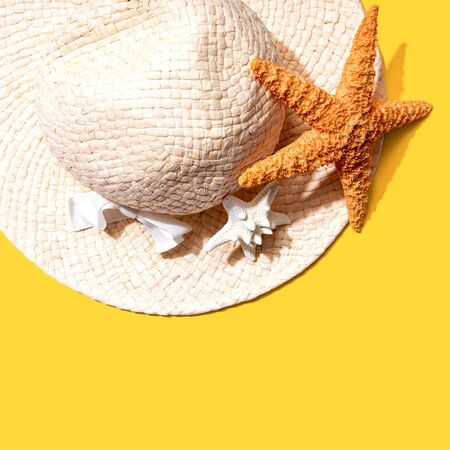 Summer concept with a straw hat and starfish overhead view - flat layの写真素材