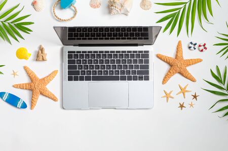 Working vacation them with laptop and beach travel itemsの写真素材
