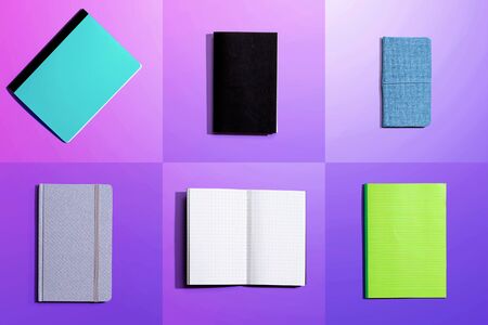 Variety of notebooks and notepads on tiled desk flatlay from above