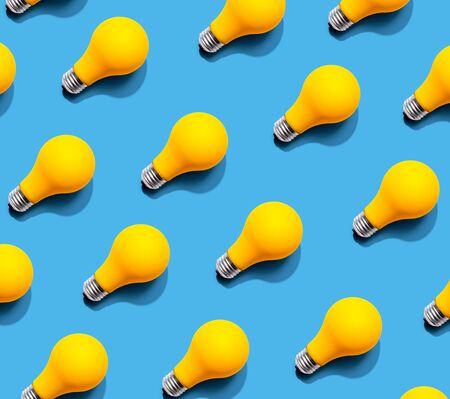 Yellow light bulb pattern with shadow - flat lay