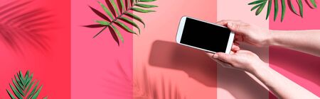 Smartphone with tropical palm leaves and shadow - flat layの写真素材