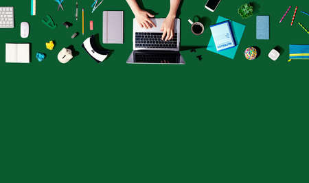 Person using a laptop computer with office supplies - flat la