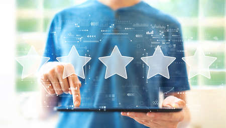 Rating star concept with young man using a tablet computer