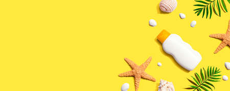 Sunblock bottle with starfish and seashells - flat lay
