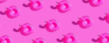 Summer concept with pink flamingo floats - flat layの写真素材