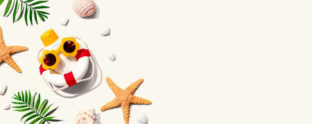 Sunblock bottle wearing sunglasses with starfish and seashells - flat layの写真素材