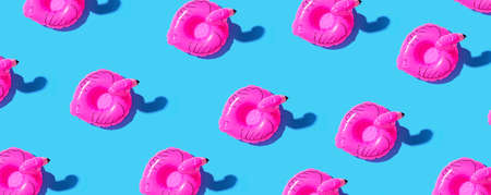 Summer concept with pink flamingo floats - flat lay