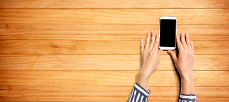 Person using a white smartphone from aboveの写真素材