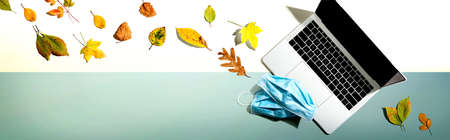 Laptop computer with masks in autumn - overhead viewの写真素材