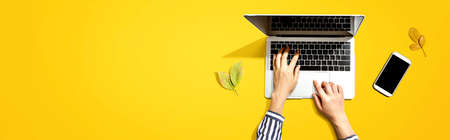 Autumn leaves with person using a laptop computer from aboveの写真素材