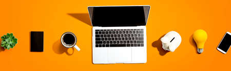 Laptop computer with a piggy bank and office objectsの写真素材