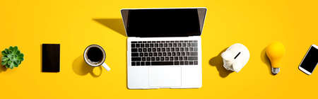 Laptop computer with a piggy bank and office objectsの写真素材