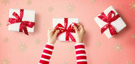 Person making Christmas gift boxes - overhead viewの写真素材
