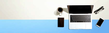 Laptop computer with a smartphone and office objectsの写真素材