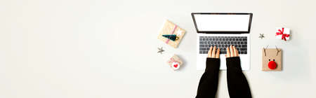 Person using a laptop computer with Christmas gift boxes from above
