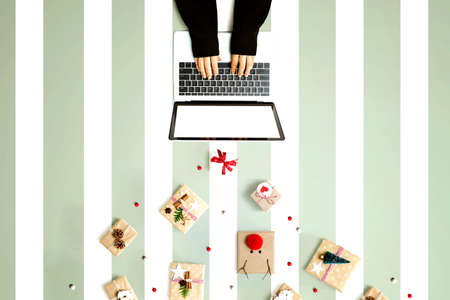Person using a laptop computer with Christmas gift boxes from above
